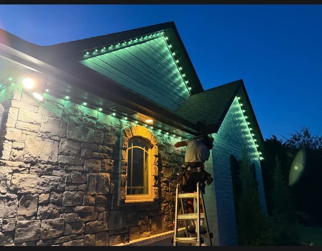 Stone home lit green and blue during install