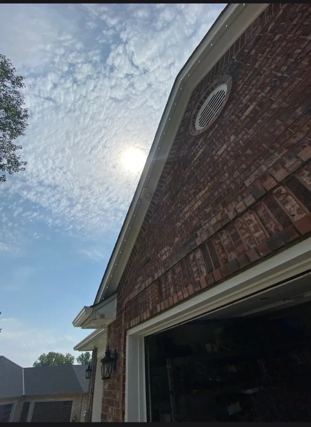 New seamless gutters on a gray two-story home with a wraparound porch