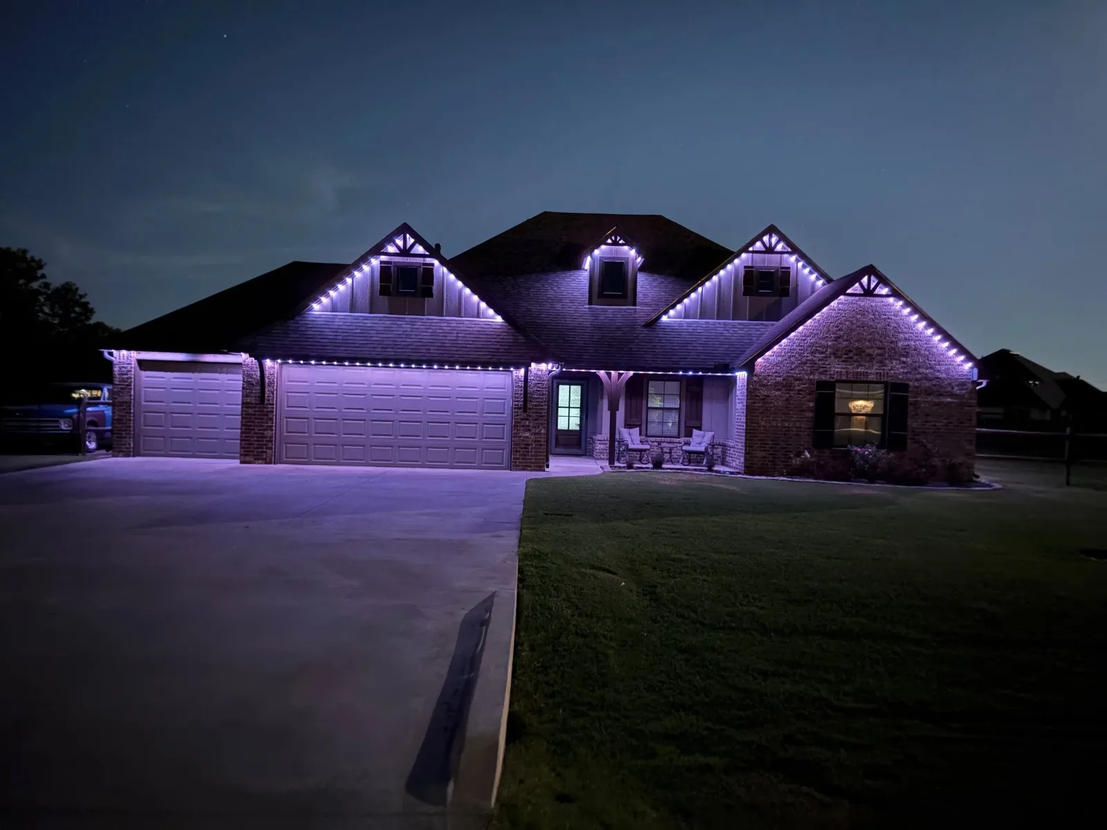 Brick ranch home in purple and white at night