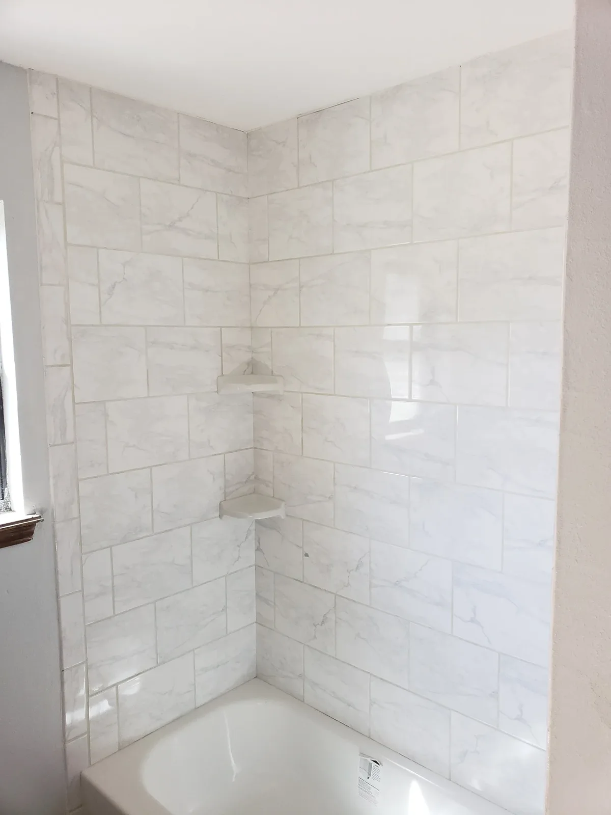 Tiled shower with white marble-look tile